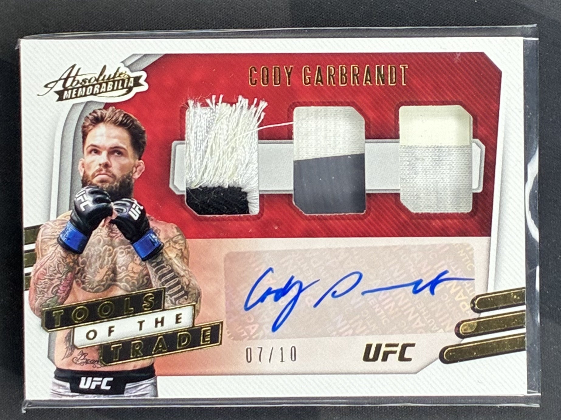 2021 Panini Chronicles UFC Cody Garbrandt Tools of the Trade Gold Relic numbered to 10 trading card in Near Mint condition.